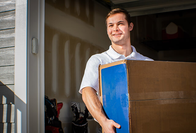 Junk removal professional hauling a box of junk